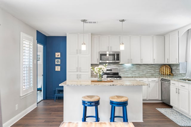 kitchen featuring stainless steel appliances, dark wood finished floors, decorative backsplash, and white cabinetry