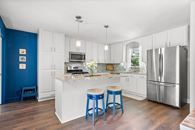 kitchen featuring arched walkways, visible vents, dark wood finished floors, and stainless steel appliances