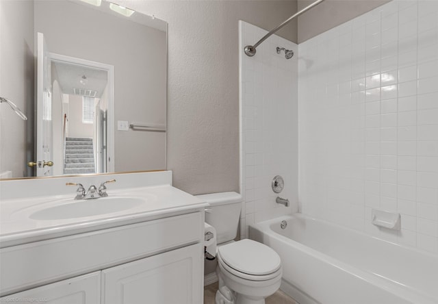 bathroom with vanity, visible vents, bathtub / shower combination, toilet, and a textured wall