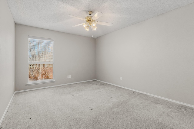 carpeted empty room featuring baseboards, a textured ceiling, and a ceiling fan