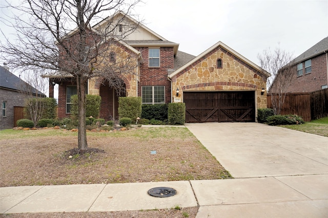 traditional-style house featuring brick siding, fence, concrete driveway, stone siding, and an attached garage