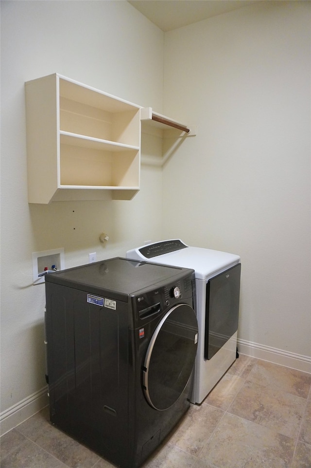 washroom with washer and dryer, baseboards, and laundry area