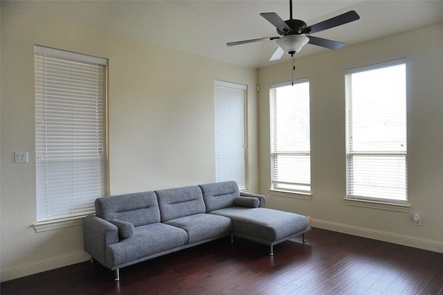 living room featuring baseboards, dark wood-style flooring, a wealth of natural light, and ceiling fan