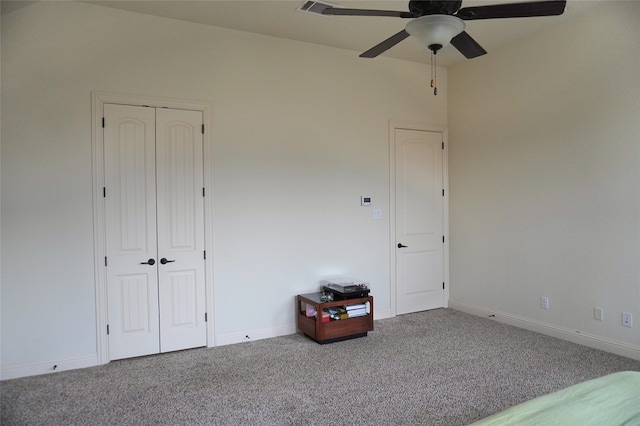 unfurnished bedroom with a closet, baseboards, carpet, and a ceiling fan