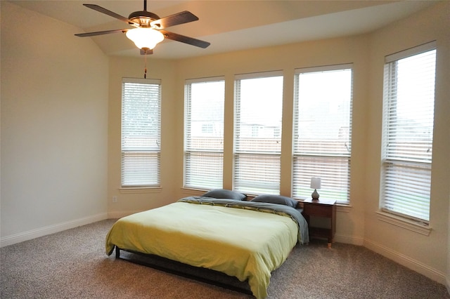 carpeted bedroom featuring baseboards, multiple windows, and ceiling fan