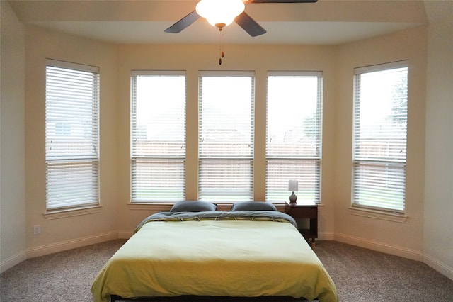 bedroom featuring light colored carpet, baseboards, and ceiling fan