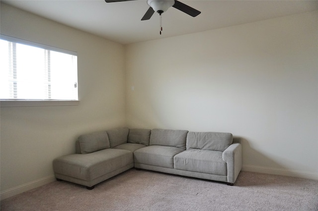 living room with baseboards, light carpet, and ceiling fan