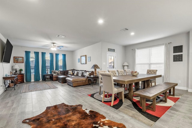 dining room with light wood finished floors, visible vents, baseboards, and a ceiling fan