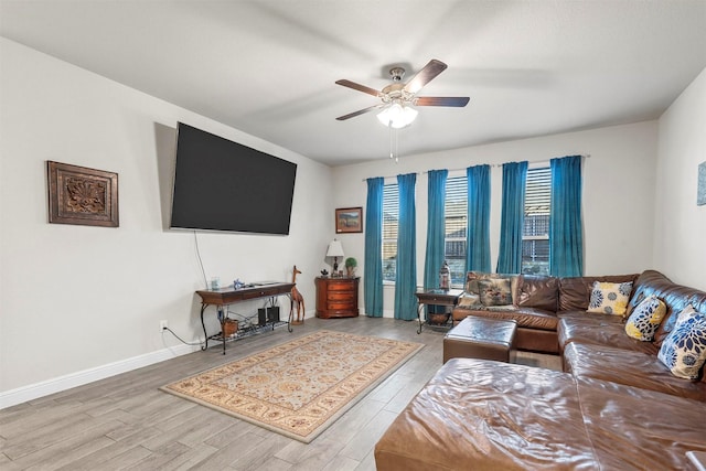 living room with baseboards, ceiling fan, and wood finished floors