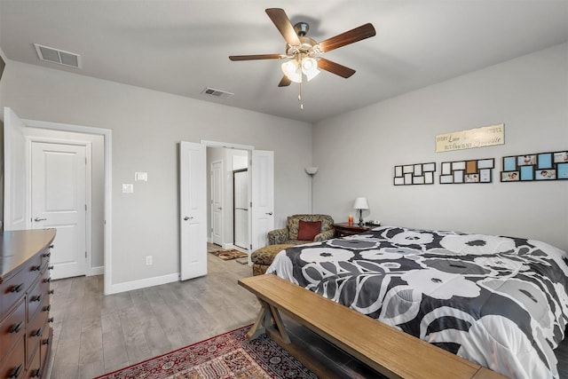 bedroom with visible vents, a ceiling fan, baseboards, and wood finished floors