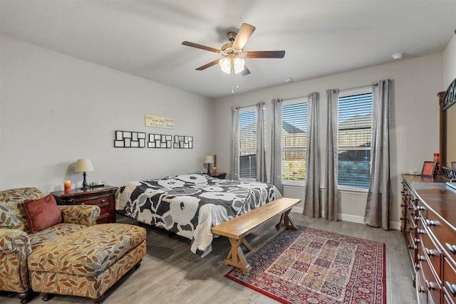 bedroom featuring baseboards, ceiling fan, and light wood finished floors