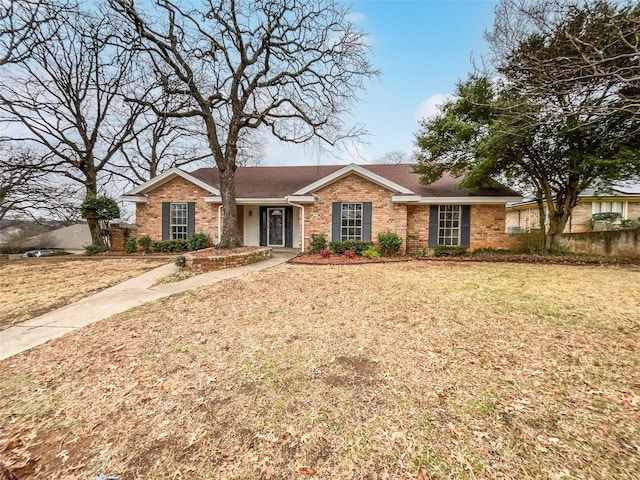 ranch-style home with brick siding, a shingled roof, and a front lawn