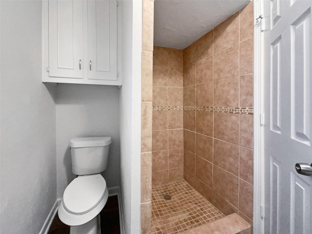 full bath featuring baseboards, toilet, and a shower stall