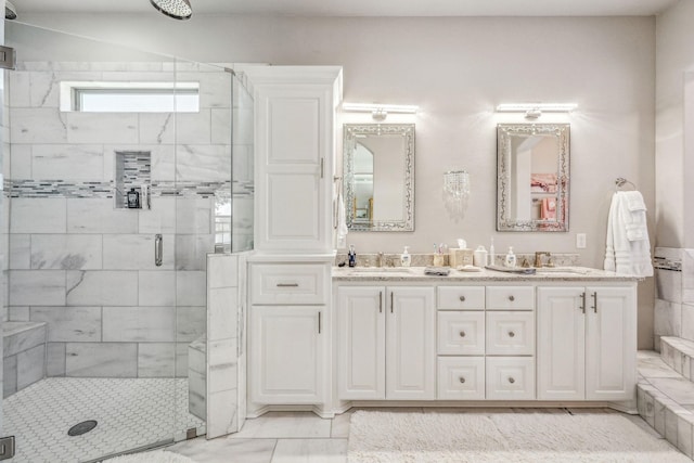 full bath with a sink, double vanity, and a shower stall