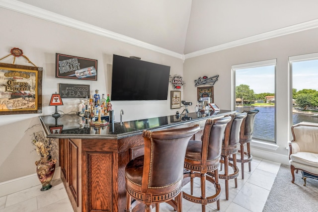 bar with light tile patterned floors, wet bar, crown molding, and vaulted ceiling