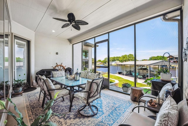 sunroom featuring a water view and a ceiling fan