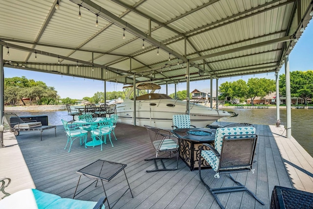 view of dock with outdoor dining space and a water view