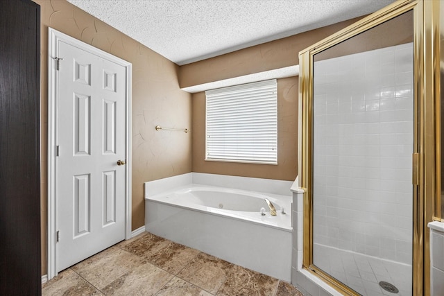 full bathroom featuring a garden tub, a stall shower, and a textured ceiling