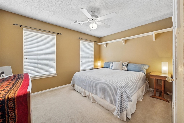 carpeted bedroom with baseboards, a textured ceiling, and ceiling fan