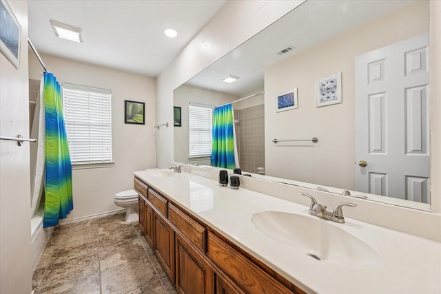 full bathroom featuring toilet, a healthy amount of sunlight, visible vents, and a sink