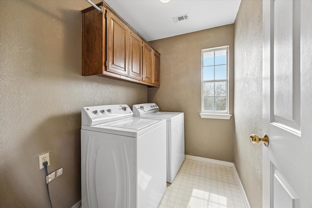 laundry room with visible vents, cabinet space, separate washer and dryer, baseboards, and light floors