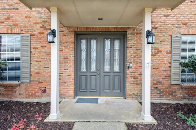 doorway to property featuring brick siding