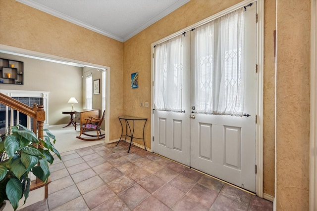 foyer entrance with crown molding, a fireplace, and baseboards