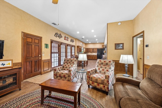 living area with recessed lighting, a wainscoted wall, visible vents, and wood finished floors