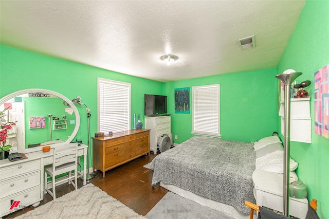 bedroom featuring visible vents and wood finished floors