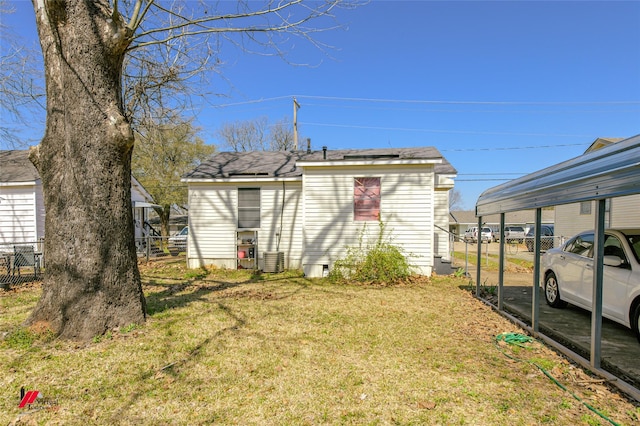 exterior space featuring a carport, fence, and central AC