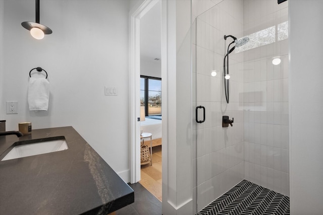 bathroom featuring vanity, wood finished floors, a stall shower, and ensuite bathroom