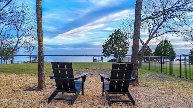 view of yard featuring fence and a water view