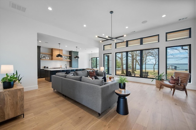 living area featuring visible vents, recessed lighting, and light wood-style floors