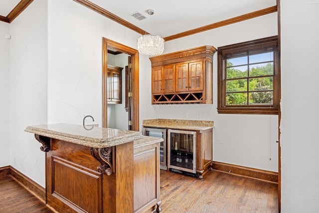 indoor dry bar with baseboards, dark wood-style floors, crown molding, a chandelier, and pendant lighting