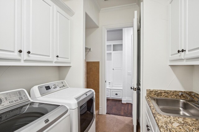 clothes washing area with washing machine and dryer, ornamental molding, cabinet space, and tile patterned flooring