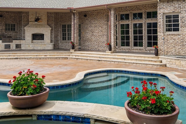 outdoor pool with a grill, a patio area, and area for grilling