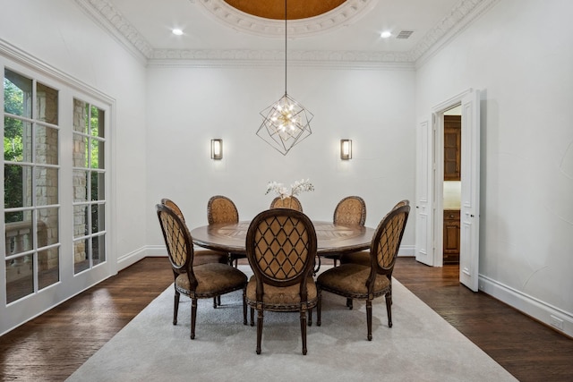 dining space featuring dark wood-type flooring, a chandelier, crown molding, and baseboards