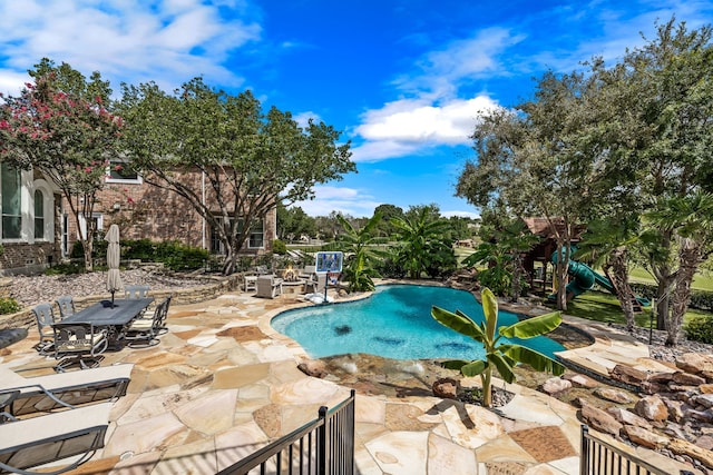 outdoor pool with a playground and a patio area