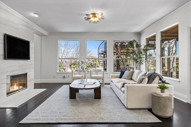 living area with baseboards, wood-type flooring, and a fireplace