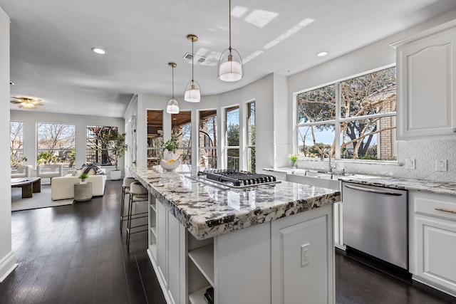 kitchen featuring white cabinets, tasteful backsplash, dark wood-style flooring, and stainless steel appliances