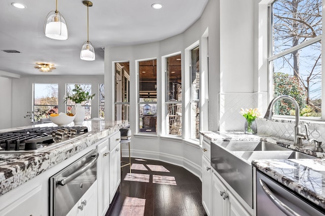 kitchen featuring decorative backsplash, appliances with stainless steel finishes, white cabinetry, a warming drawer, and dark wood-style flooring