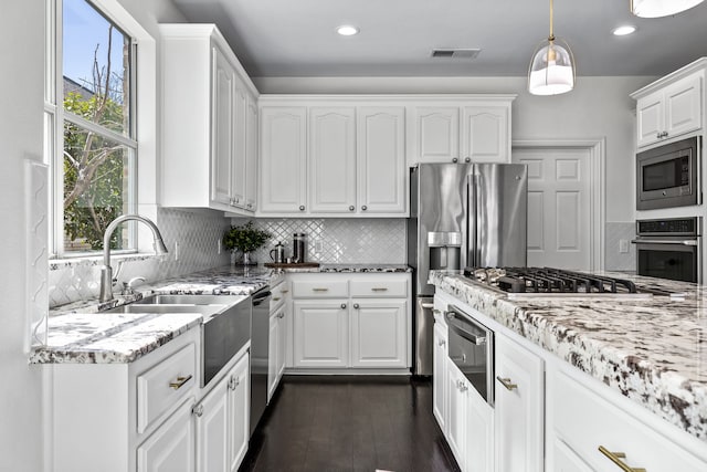 kitchen featuring visible vents, stainless steel appliances, white cabinetry, a warming drawer, and dark wood-style flooring