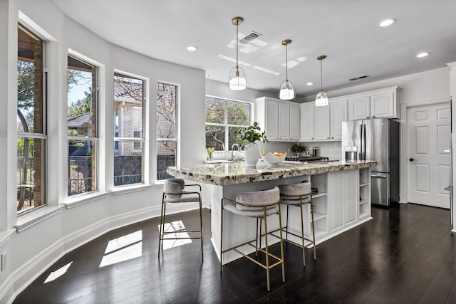 kitchen with backsplash, stainless steel fridge with ice dispenser, light stone counters, white cabinetry, and open shelves