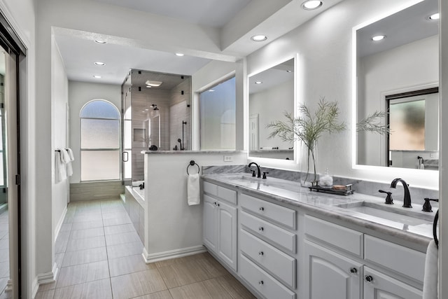 bathroom with double vanity, tile patterned flooring, a stall shower, and a sink