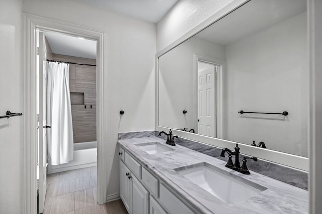 bathroom featuring double vanity, shower / tub combo with curtain, and a sink