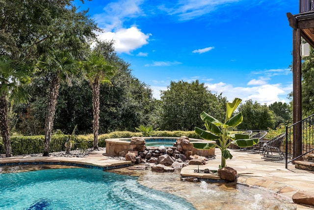 outdoor pool featuring a patio and an in ground hot tub