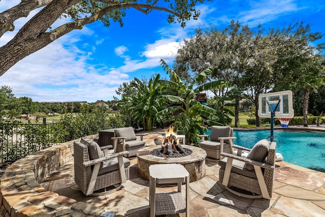 view of patio with an outdoor pool and a fire pit