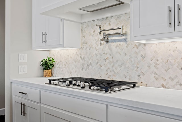 kitchen featuring tasteful backsplash, white cabinets, and light countertops