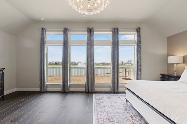 unfurnished bedroom featuring a chandelier, dark wood finished floors, baseboards, and lofted ceiling