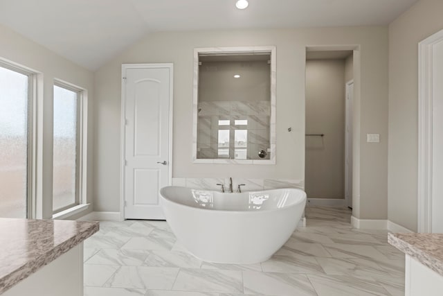 bathroom with vanity, a freestanding tub, plenty of natural light, and marble finish floor